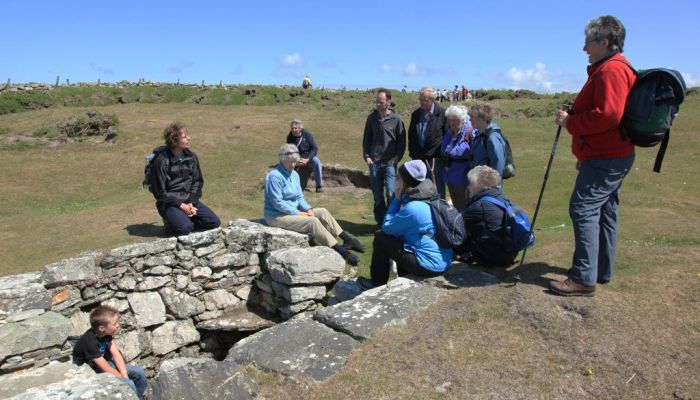 Photo of a group of walkers gathered round discussing a ruin